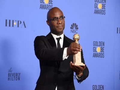 Barry Jenkins tenant un trophée