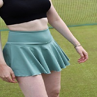 Une femme portant une jupe tennis et un crop top