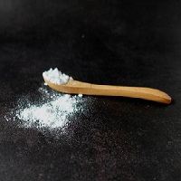 Du bicarbonate de soude débordant d’une cuillère en bois