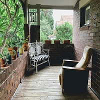 Un balcon décoré avec des fauteuils et des plantes