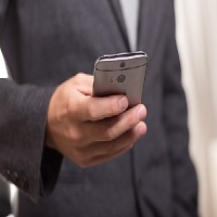 Une personne tenant un téléphone portable dans sa main droite
