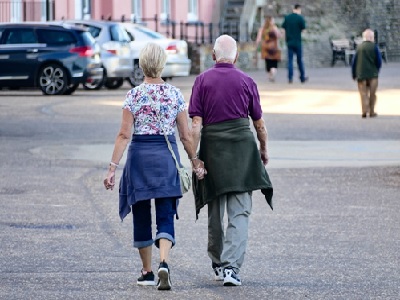 Deux personnes âgées en train de marcher main dans la main