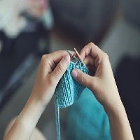 Une personne en train de tricoter avec une matière néfaste pour la planète