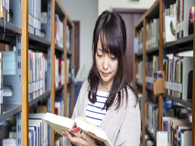Une fille lisant un livre dans une bibliothèque
