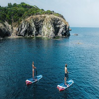 Couple sur paddle gonflable avec guidon en pleine mer