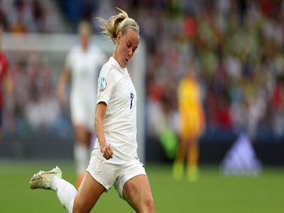 Joueuse de football sur le terrain en train de buter