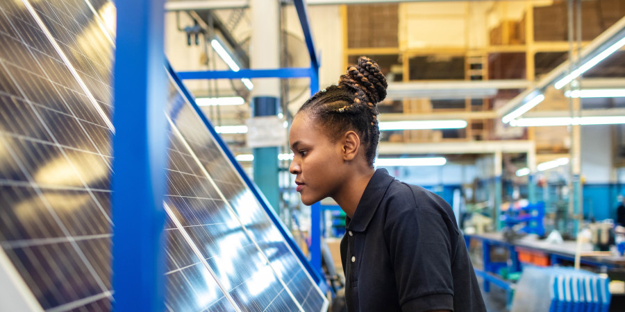 Une femme fixant un panneau photovoltaïque