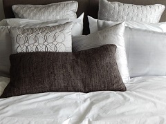 Des oreillers aux formes et designs divers posés sur un mobilier