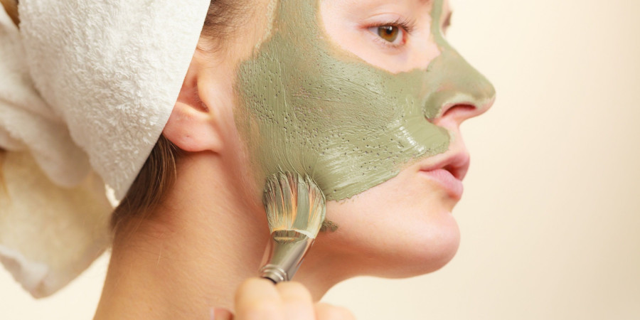 Une femme qui applique un masque sur son visage