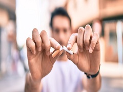 Une personne qui coupe une cigarette en deux