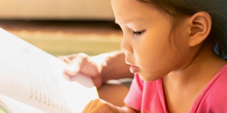 Une enfant qui lit un livre