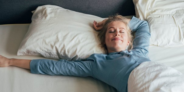 Une jeune femme qui dort dans un lit