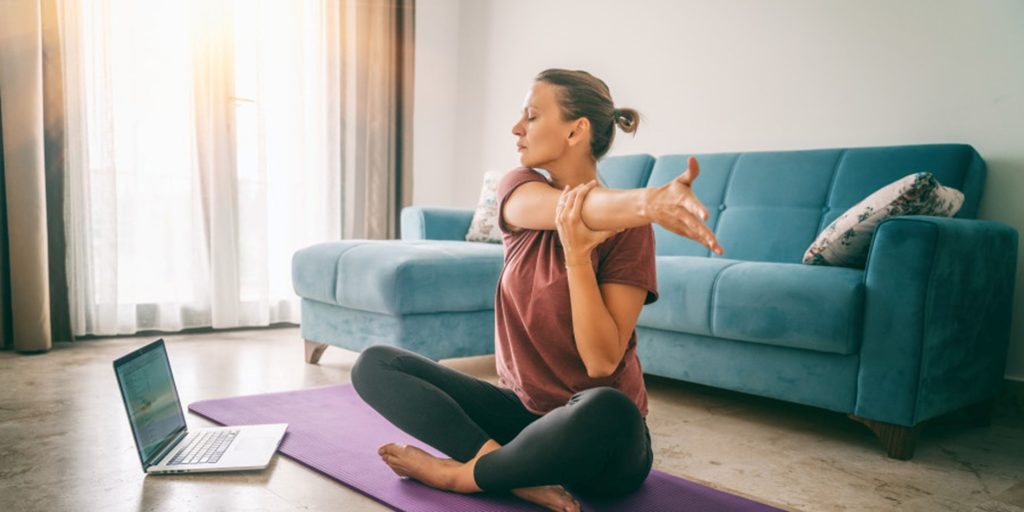 Une femme qui s’étire devant un programme de Nike Training Club