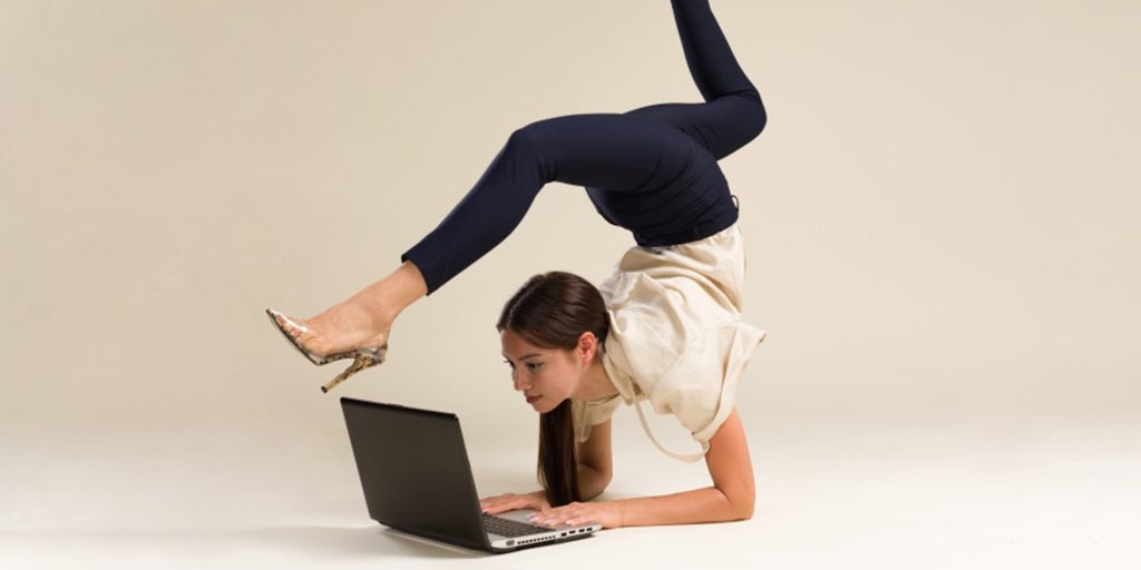 Une jeune femme qui pratique une activité physique au travail devant son ordinateur