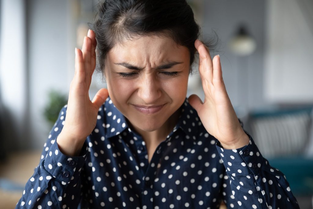 Une femme qui se tient les tempes 