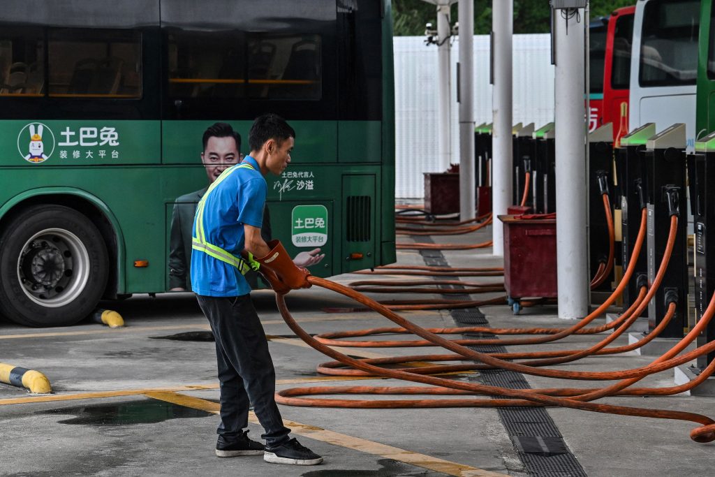 Un homme qui recharge des bus électriques