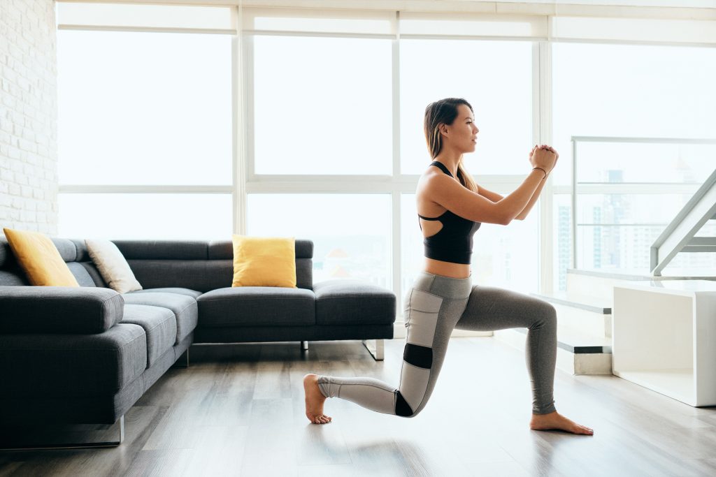 Une jeune femme qui fait des exercices a faible impact dans son salon 