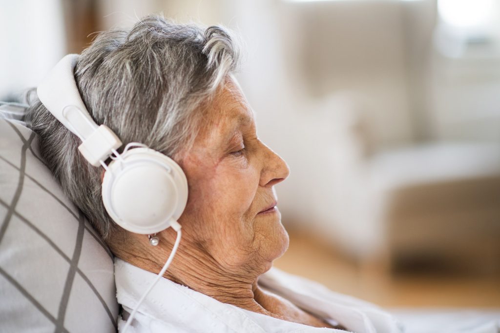 Une personne âgée qui profite des bienfaits de la musique dans un casque 