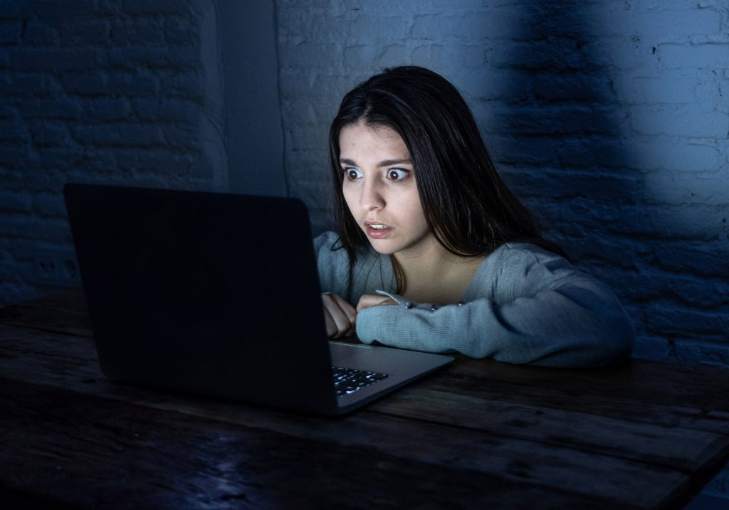 Une adolescente qui regarde un ordinateur allumé 