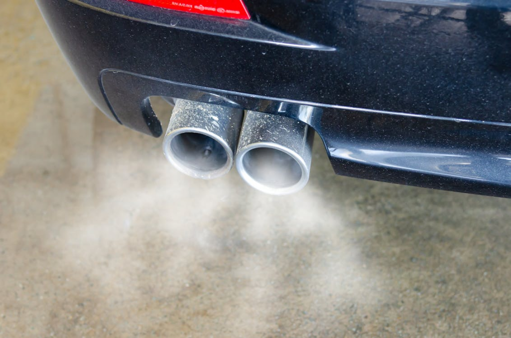 Un pot d’échappemennt de voiture émettant de la fumée.