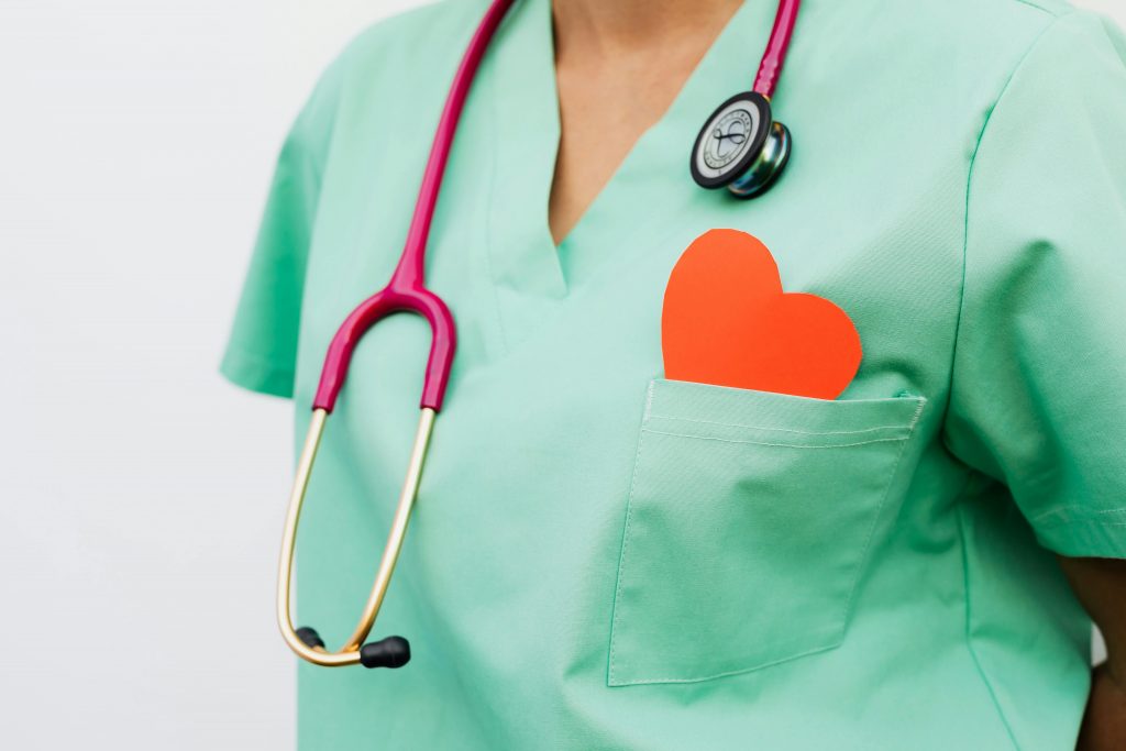 Un medecin portant une blouse avec un cœur rouge au niveau de la poche