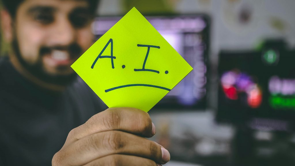 Un homme tenant un bout de papier avec l’inscription AI